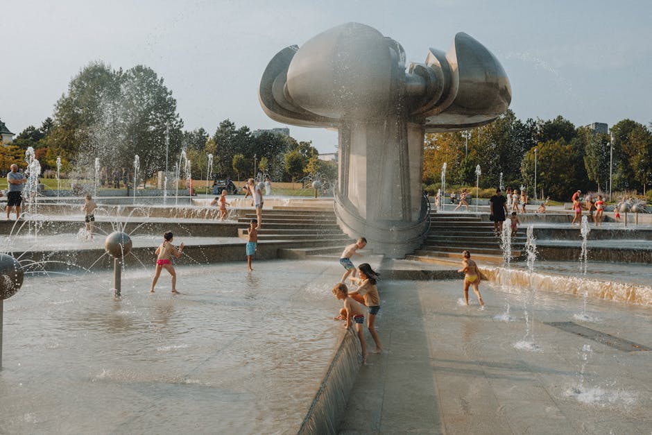 Happy children playing in an urban fountain splash pad on a sunny day