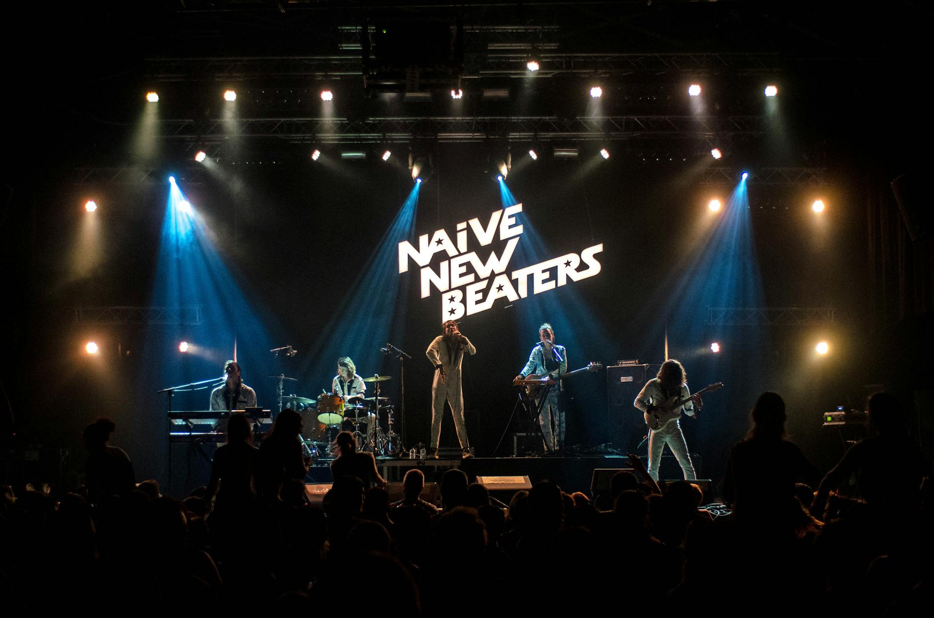 Live concert venue with stage lights and energetic crowd