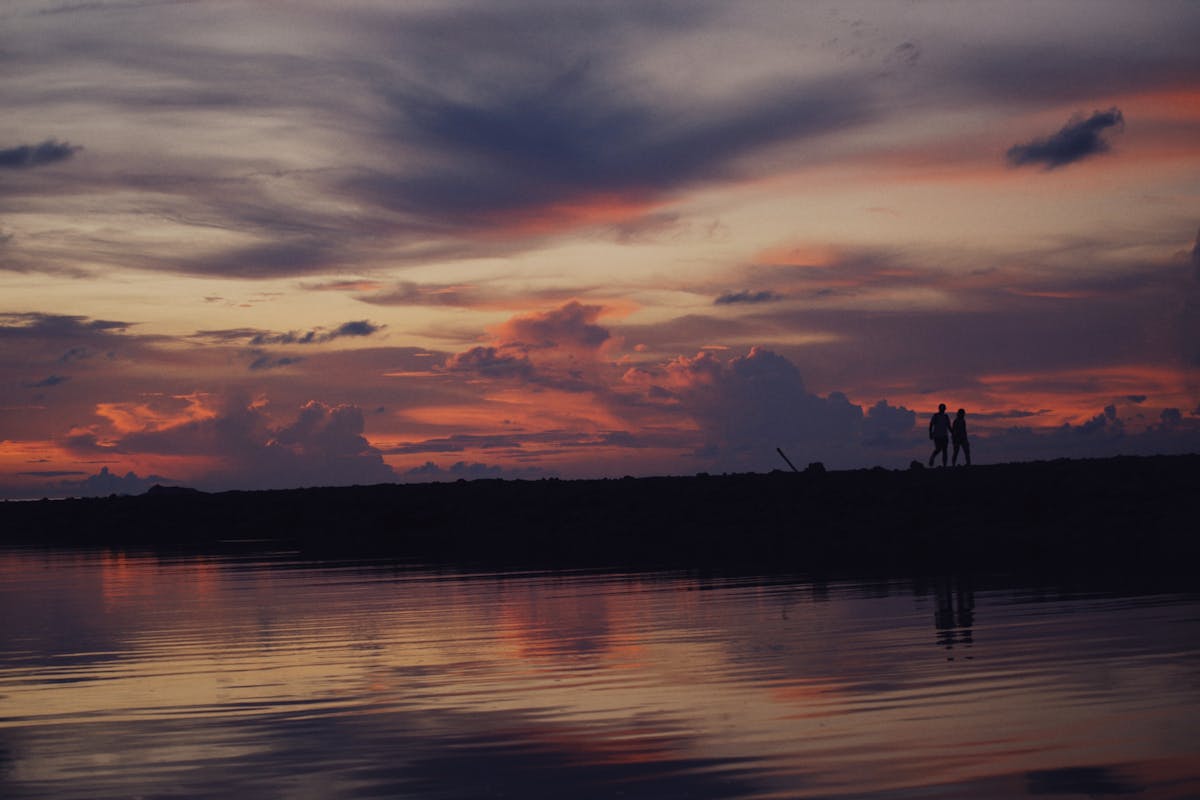 Couple walking along the waterfront at sunset