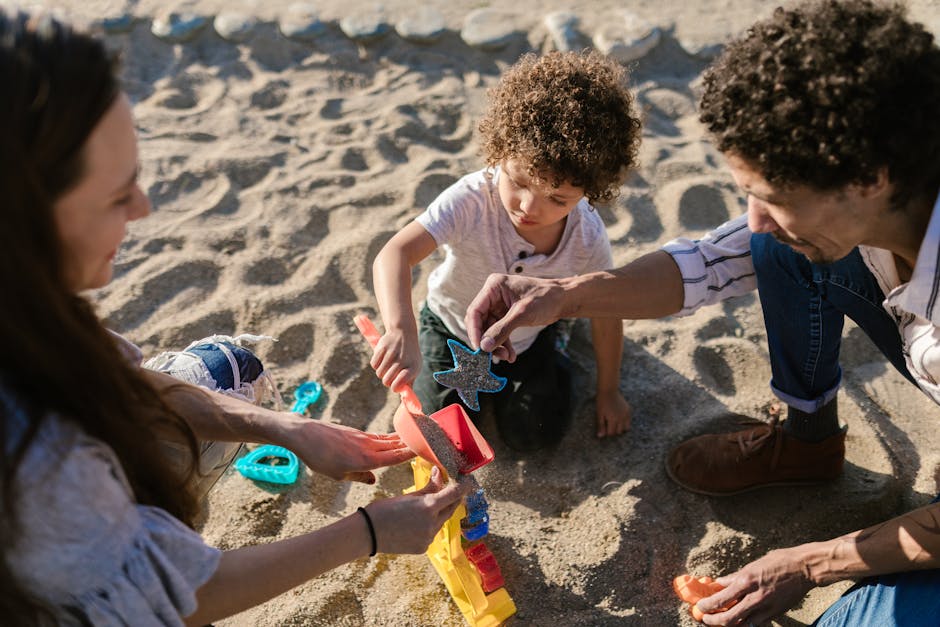Parents and child playing with sand toys and enjoying quality time at the beach