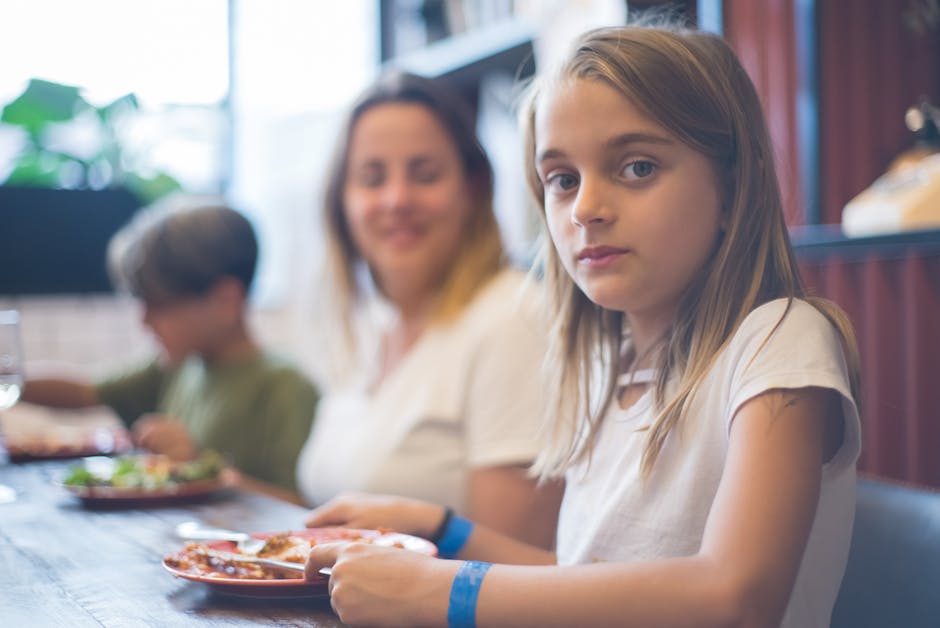 A family enjoying a meal together at a restaurant with kids