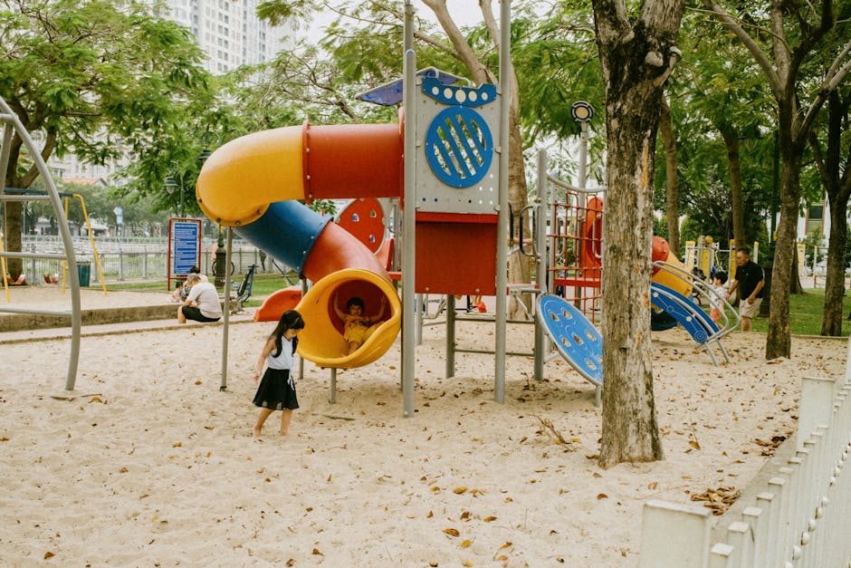 Children playing on colorful playground equipment in a city park