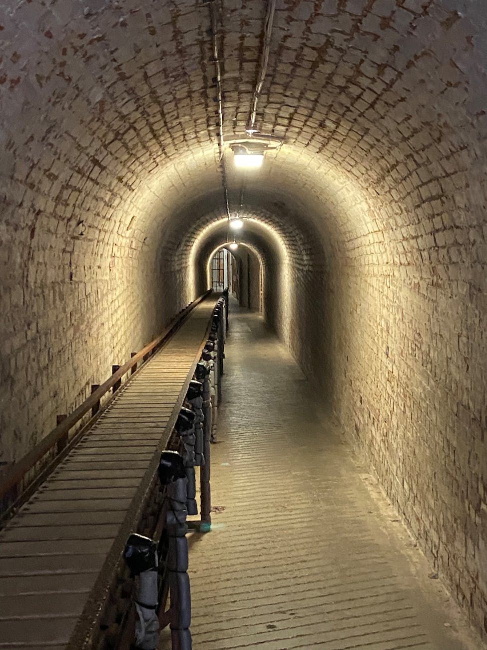 Atmospheric underground tunnel with brick walls and wooden walkway