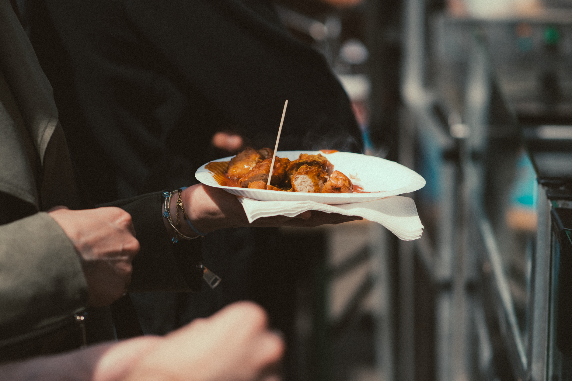 Street-food tasting plate in hand on a guided market food tour