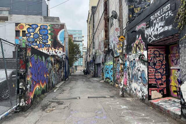 Graffiti Alley in Toronto, a narrow laneway lined on both sides with colourful murals and graffiti-covered garage doors