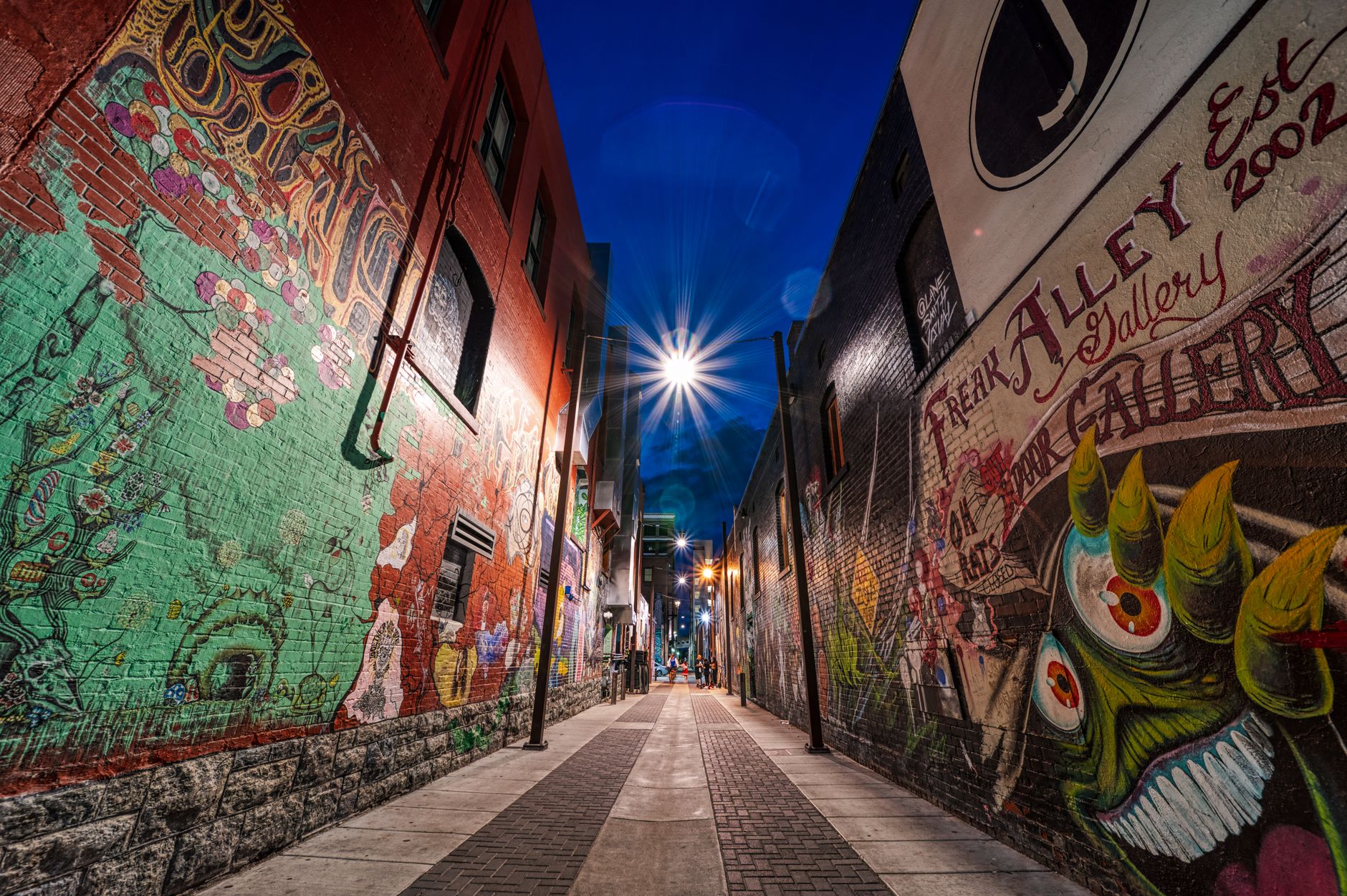 Narrow alley walls covered in colourful spray-painted murals