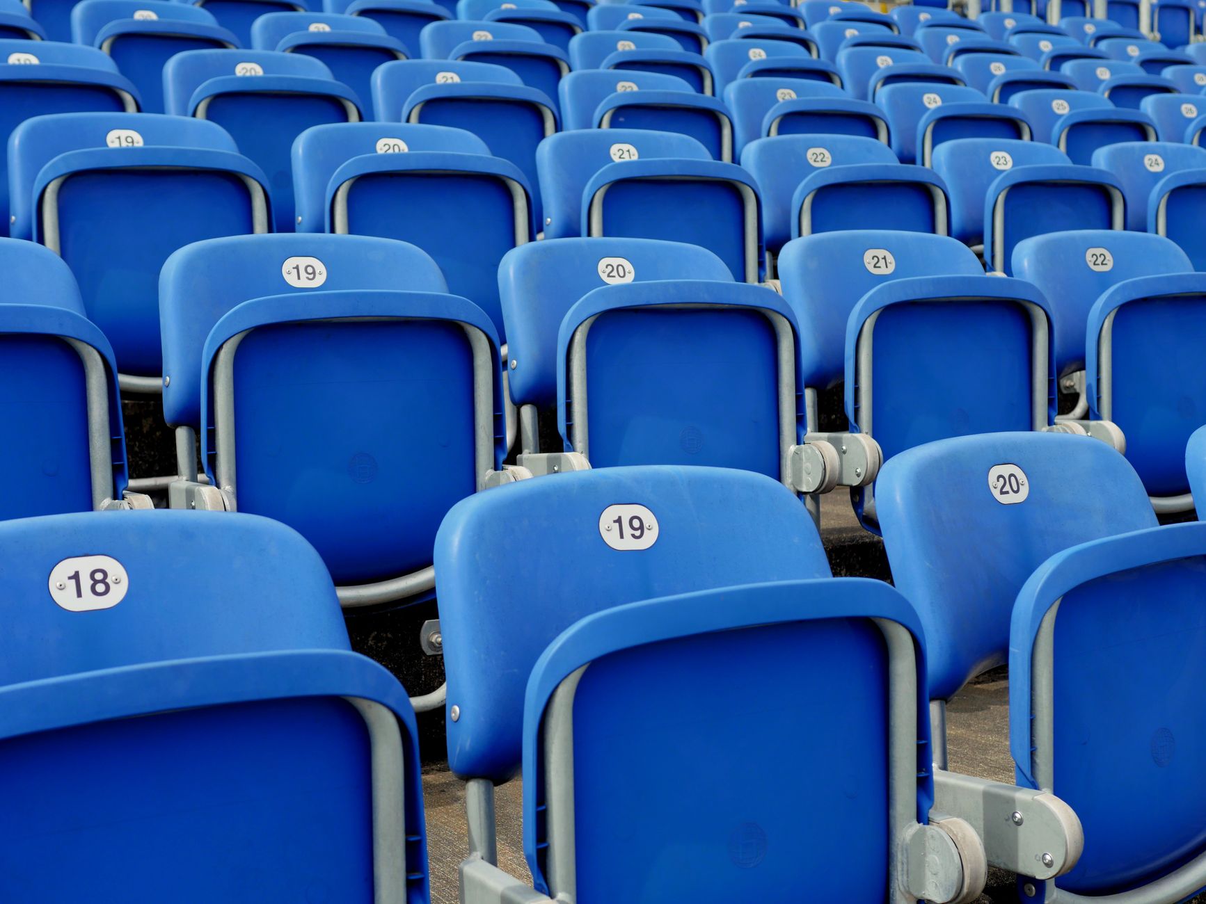 Rows of empty blue stadium seats before the gates open