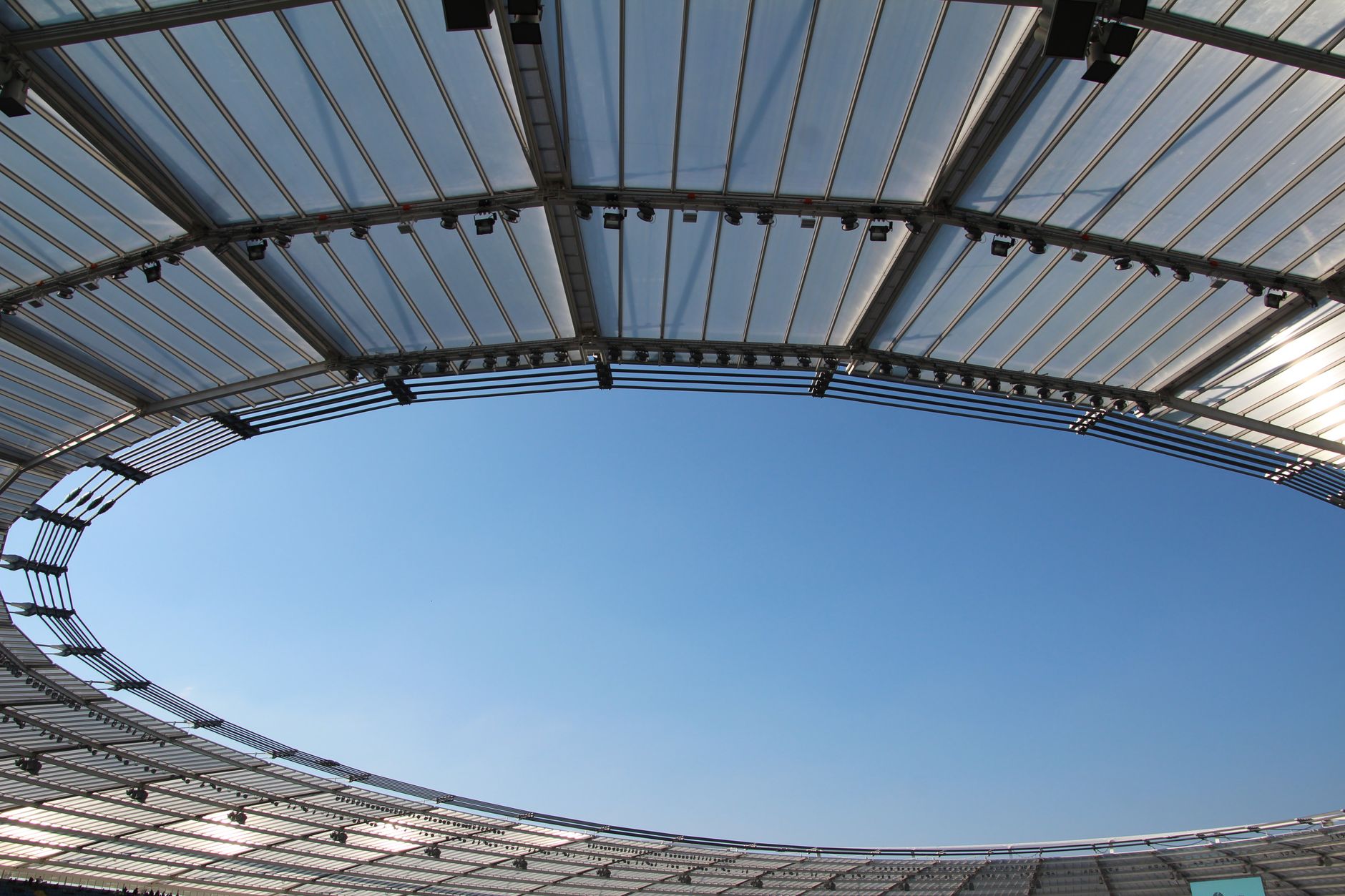 The domed retractable roof of a downtown stadium against a clear sky