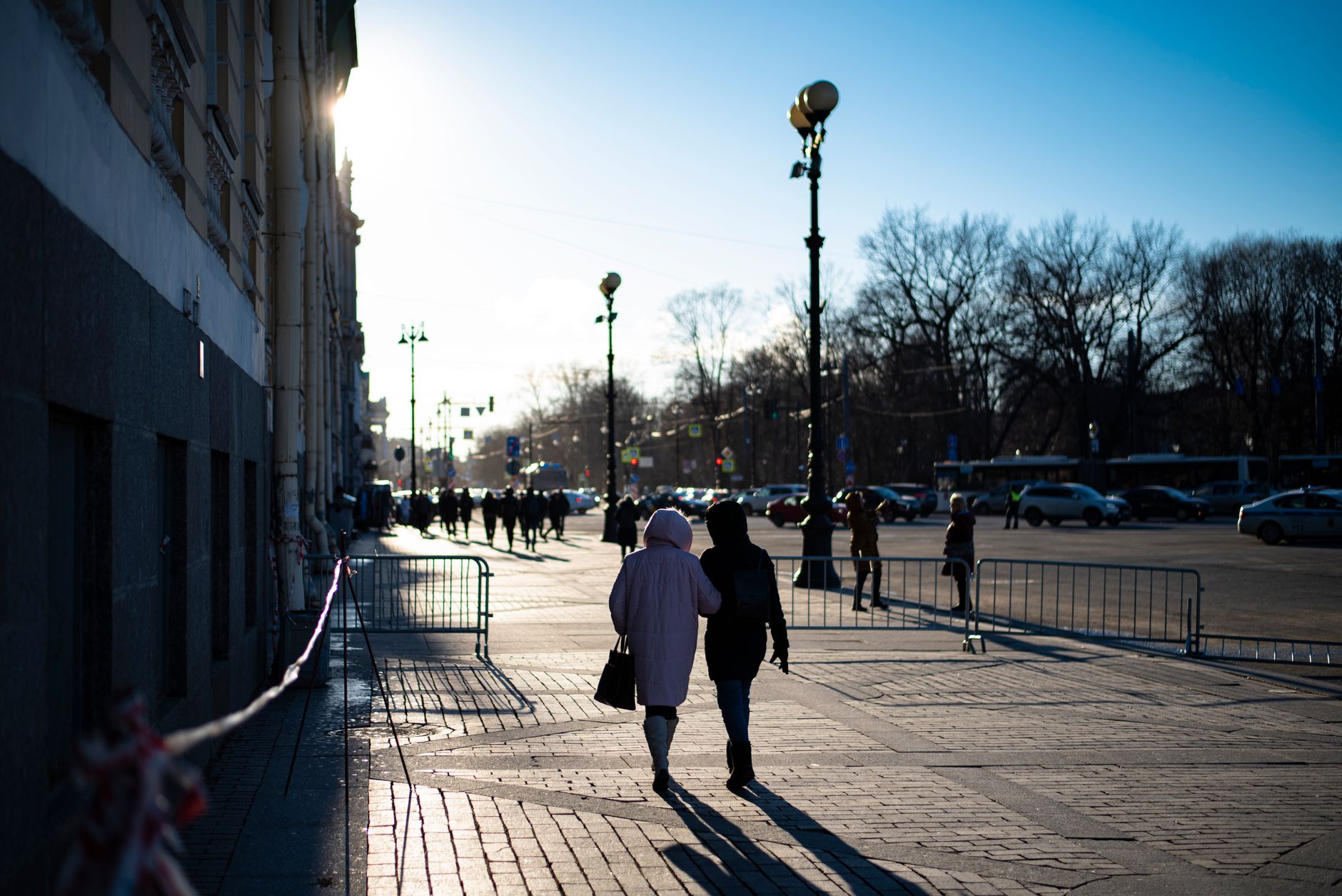 Pedestrians walking a downtown street at dusk on their way to a game