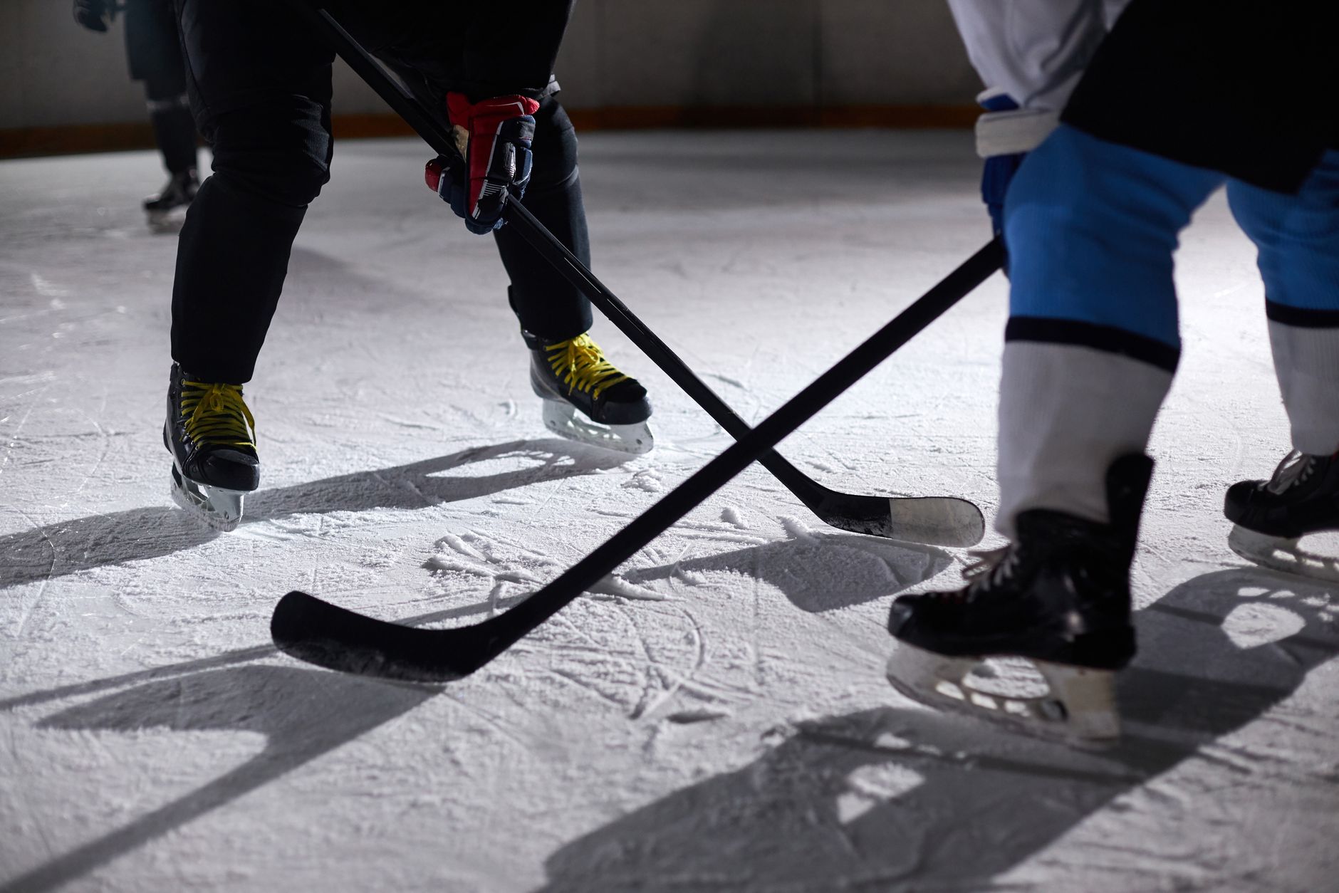 Hockey players on the ice during a game, viewed from ice level