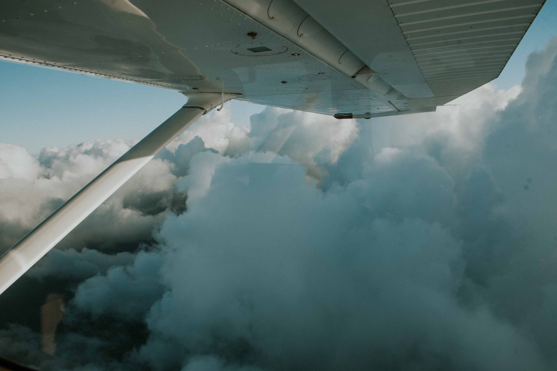 Aircraft wing seen above a layer of cloud from a passenger window