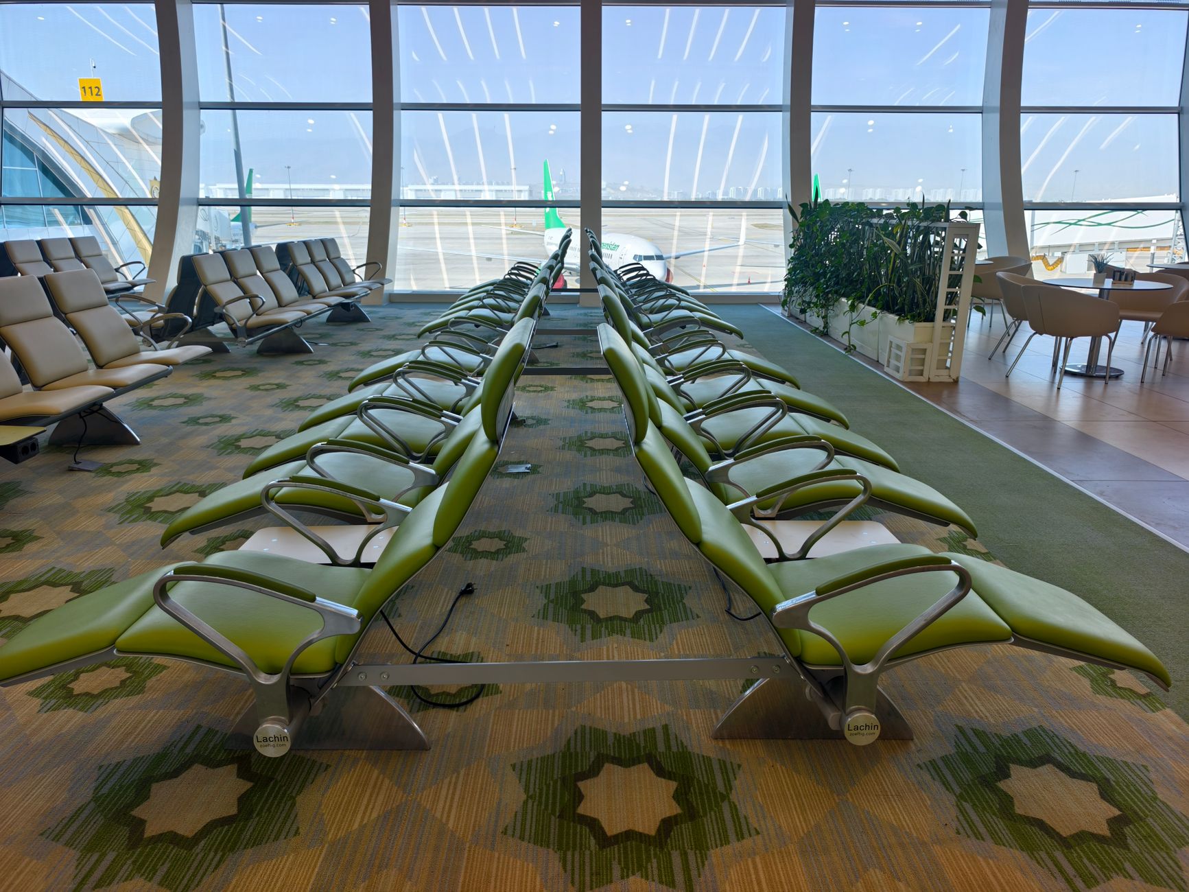 Comfortable airport lounge seating with armchairs and tall windows