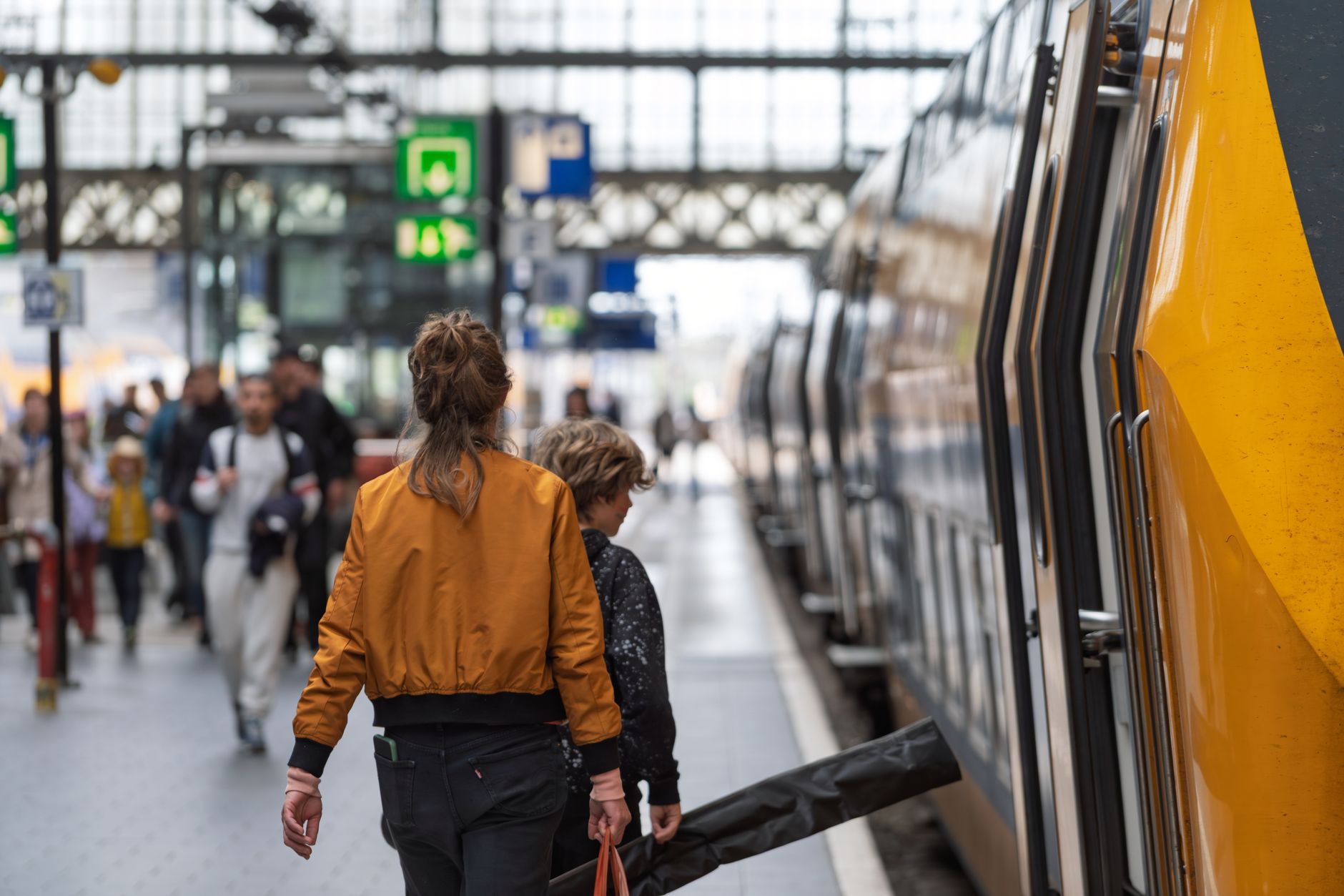 Passengers boarding a train at a station platform with luggage