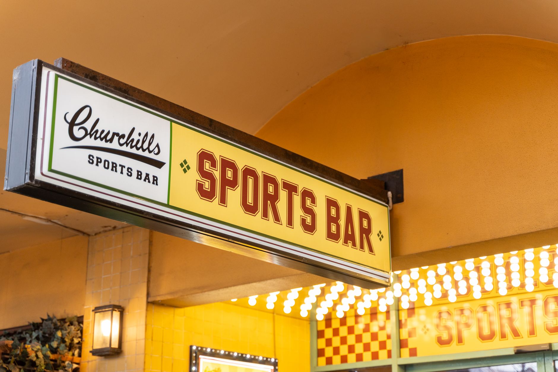 Sports bar sign glowing outside a downtown pub where fans watch Toronto sports on game night